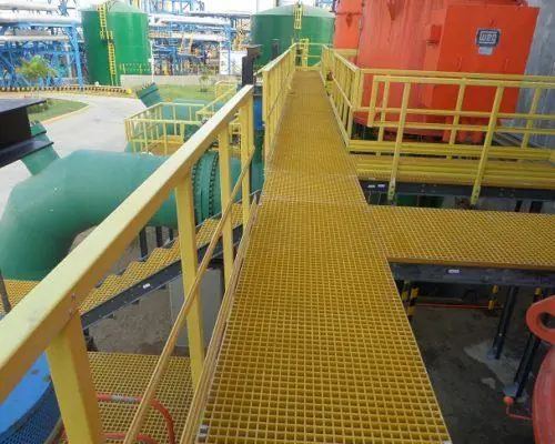 Elevated grating bridge walkway between industrial structures